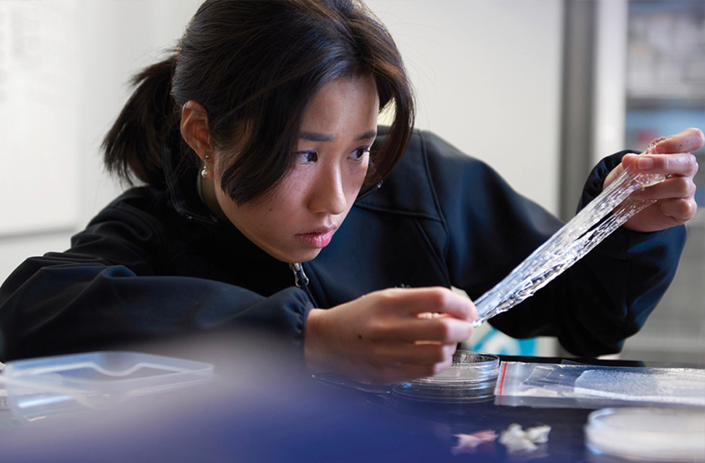 Tiffany Yeh, MD, pulls apart a piece of stretchy translucent material that is part of a cold therapy wearable product